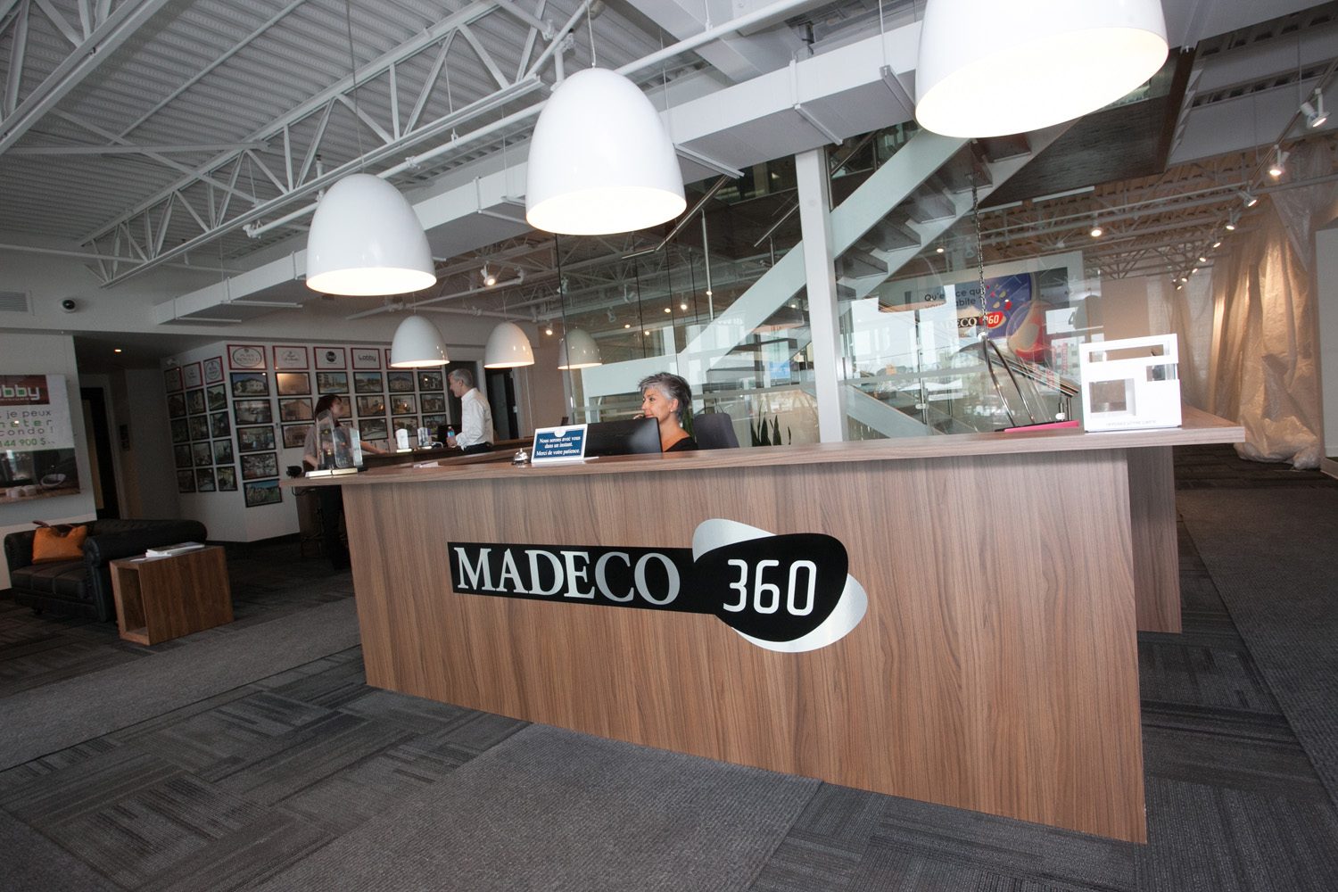 L'accueil des bureaux de Madeco : comptoir de bois, enseigne Madeco 360, plafond industriel blanc